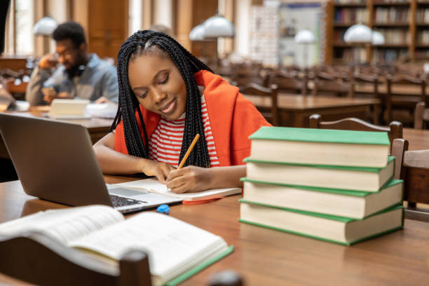istock Long-haired young woman studying in the library 2154478960