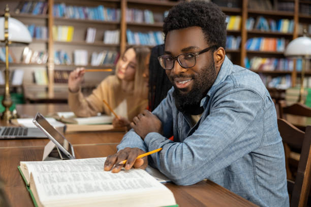 istock Curly-haired bearded african american man in the library looking thoughtful 2154479046