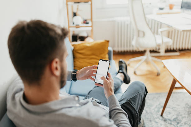 istock View over shoulder of man using smartphone 2154483782