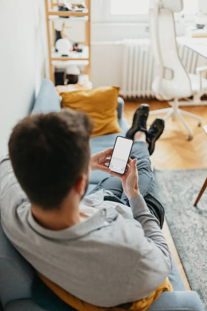istock Man on couch looking at phone with blank screen 2154483811
