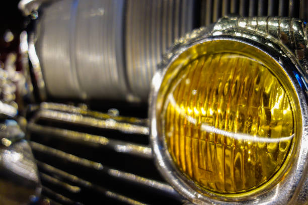 old car headlight in yellow color , closeup view.