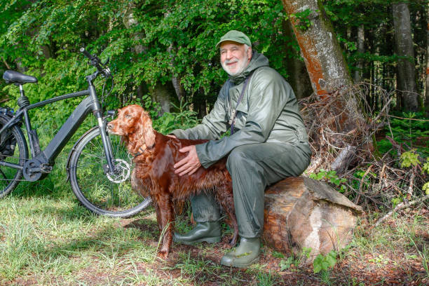 istock Resting by nature's side,  a elderly man and his Irish Setter companion. 2154486112