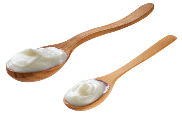 istock wooden spoon with yogurt isolated on a white background. 2154490817
