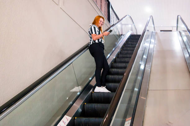 istock Woman in a escalator and using smartphone 2154490914