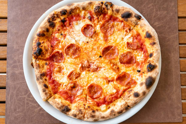 istock Close-up image over plates of freshly baked pepperoni pizza 2154492528