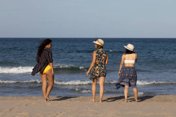 istock Three girl on their backside on the seashore 2154493638