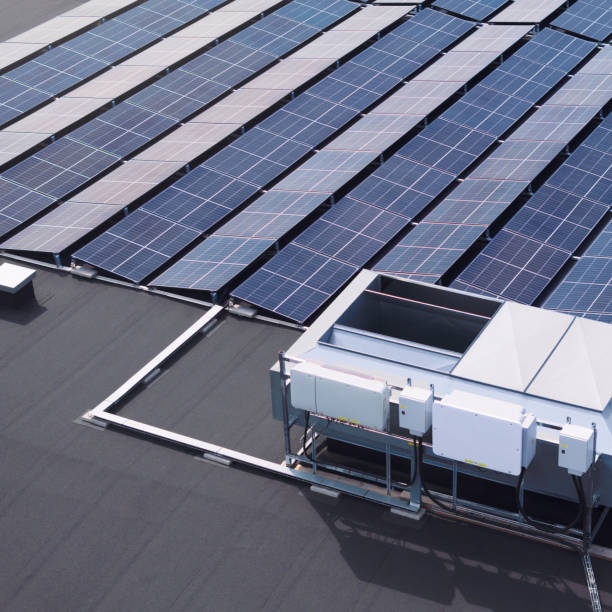 Modern solar power installation on the roof of a building A modern solar panel installation on the roof of a large industrial building. solar panels on the roof of building in a city stock pictures, royalty-free photos & images