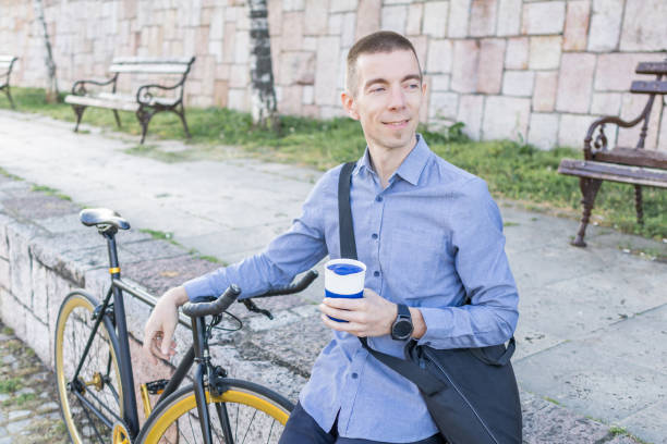 istock Smiling businessman commuter is enjoying in coffee break at public park on his trip from work after a long workday. 2154496814