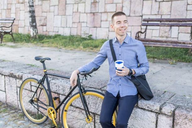 istock Smiling businessman commuter is enjoying in coffee break at public park on his trip from work after a long workday. 2154497313