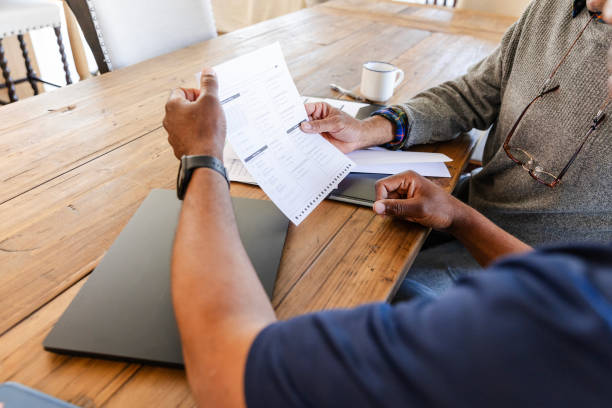 istock Two unrecognizable men sit at the dining room table to talk about retirement options 2154498396