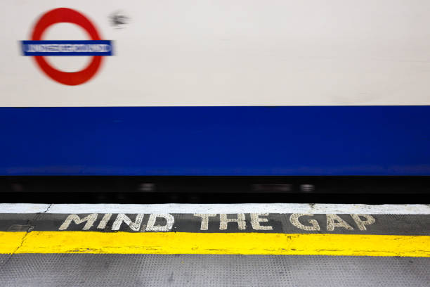 London, UK - March 24, 2024; Mind The Gap warning on platform with blurred passing London Underground train