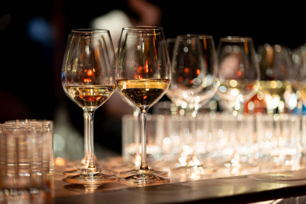 istock Bartender pours red wine in glasses on wooden bar counter 2154512781