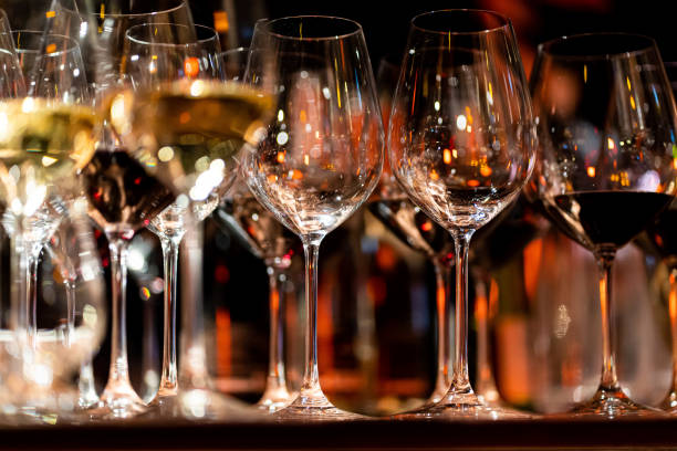 istock Bartender pours red wine in glasses on wooden bar counter 2154512788