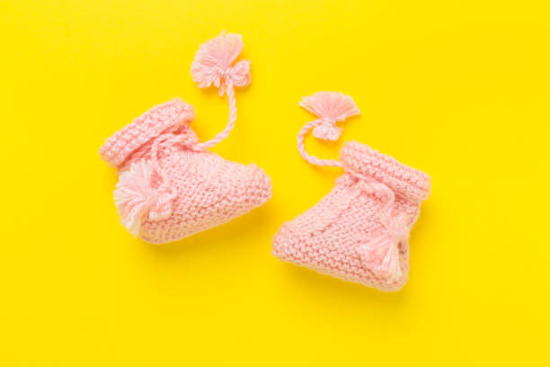 istock Pink baby booties on color background, top view 2154514592