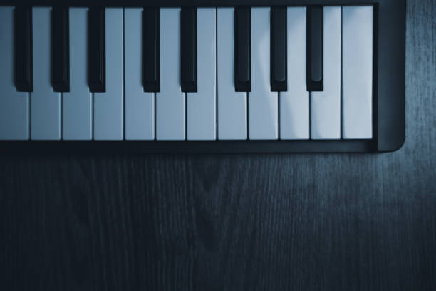 Black midi keyboard on a wooden table. Musical instrument. High quality photo
