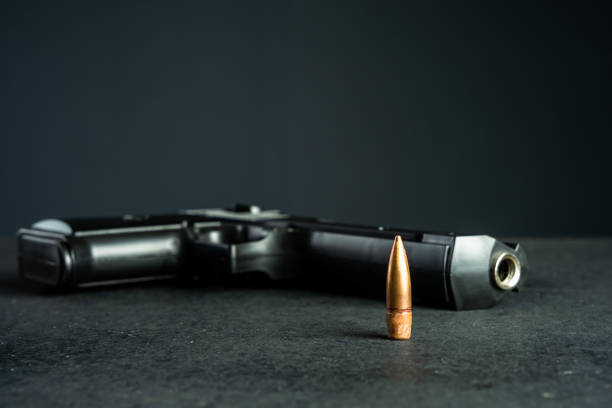 gun and bullet on black table, criminal concept