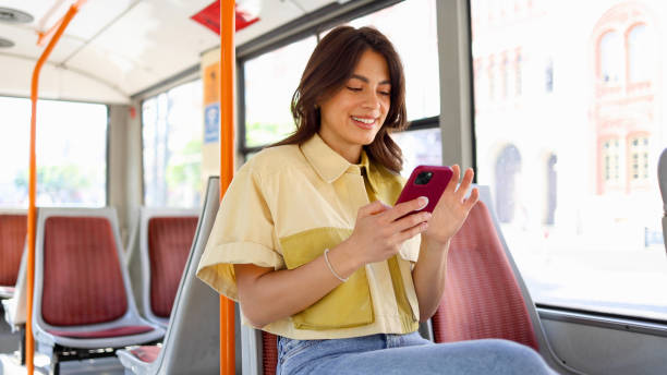 istock Young Latin woman using smartphone and riding in the bus 2154519892