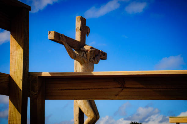A rustic crucifix set against the backdrop of charming coastal huts and a brilliant blue sky. This photograph, taken at Playa de los Botes in La Paloma, Rocha, Uruguay, captures the blend of natural beauty and human elements in a seaside setting.