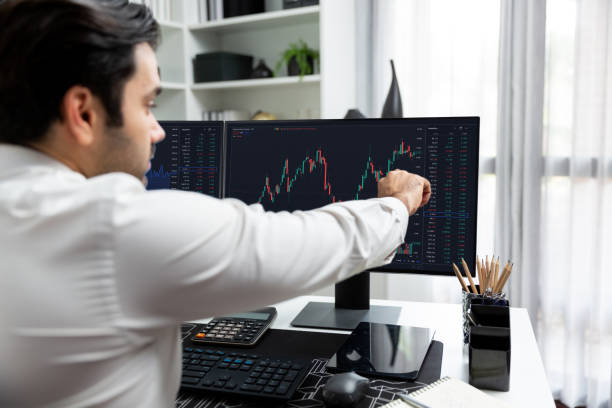 istock Trader calling to consultant or partner with two stock exchange screen. Surmise. 2154523186