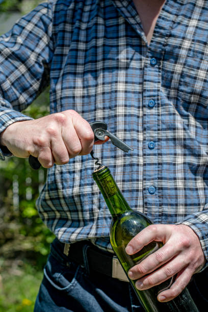 istock Close-Up of Homeowner Using Waiter-Style Corkscrew to Open White Wine Bottle 2154526102