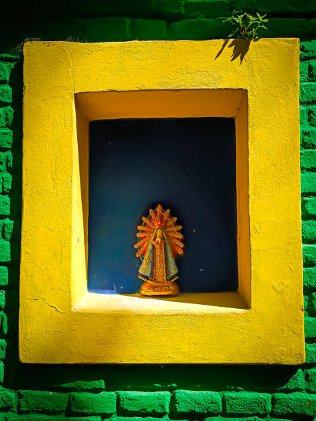 In the vibrant neighborhood of La Boca, Buenos Aires (near to Caminito), a small shrine nestled in a brightly painted wall catches the eye. The vivid green, yellow, and blue frame a statuette of the Virgen de Luján, radiating a sense of reverence and cultural pride. This charming display reflects the area's rich artistic spirit and deep-rooted faith, harmonizing tradition with the lively aesthetic of the community.