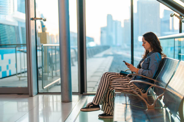 istock Woman using smartphone while waiting in airport departure area 2154538212
