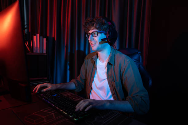 istock Smiling streamer with joystick, focusing Esport team on pc with harder. Gusher. 2154541435