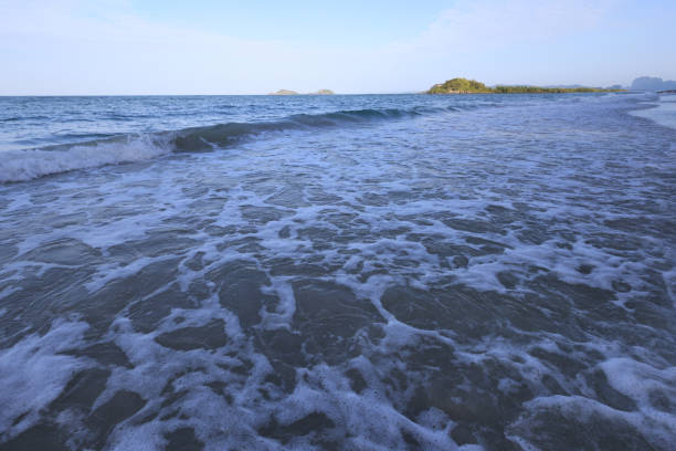 Bright Blue Cloudy Sky Over a Teal Ocean Waves Sweeping Across the Highland Beach, Florida Seashore in September of 2022
