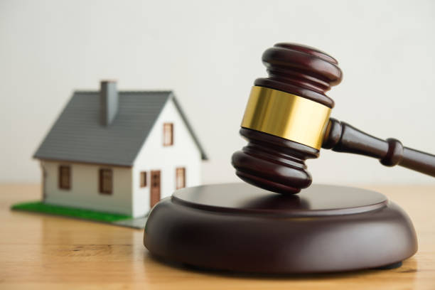 istock House model, hammer judge gavel on wooden table with white wall background. 2154545794
