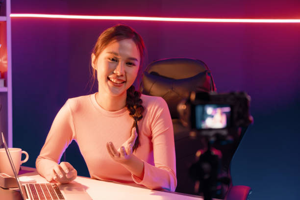 istock Smiling Asian influencer recording on camera with positive. Stratagem. 2154546015