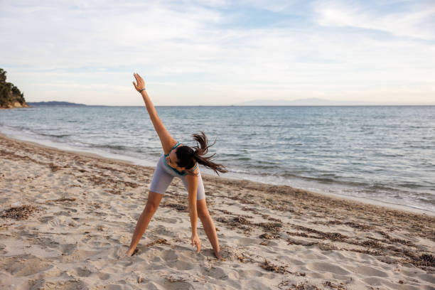 istock Young woman exercising on the beach 2154548295