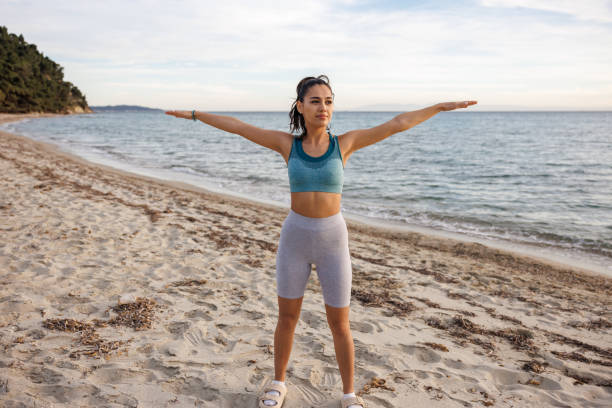 istock Young woman exercising on the beach 2154548318