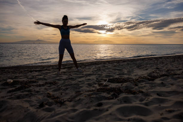istock Young woman exercising on the beach 2154548361