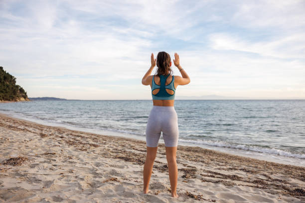 istock Young woman stretching on the beach 2154548398