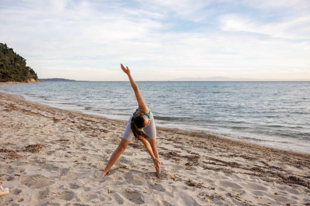 istock Young woman exercising on the beach 2154548416