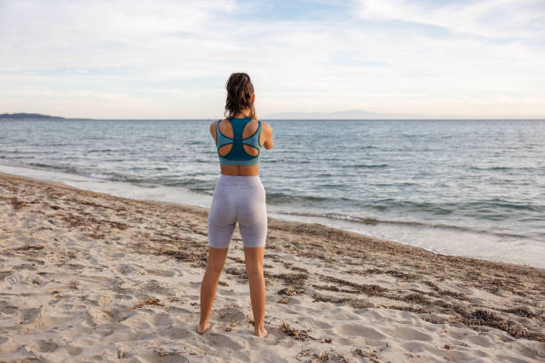 istock Young woman stretching on the beach 2154548475