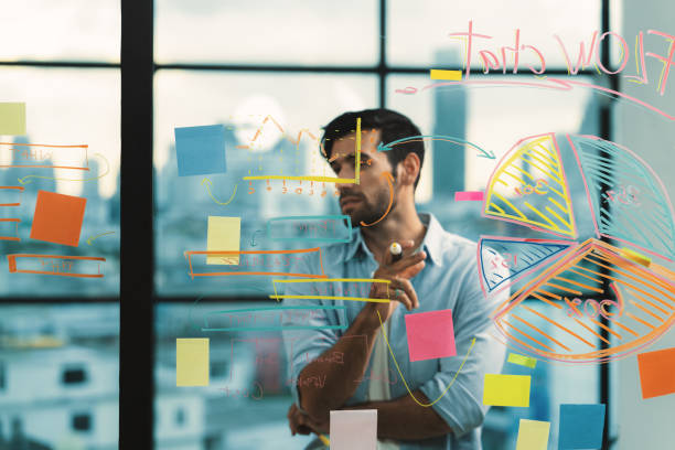 istock Smiling smart businessman writing while thinking about business plan. Tracery. 2154548650