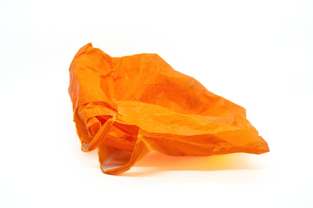 istock orange plastic bag crumpled on white background. Copy space 2154549130