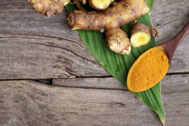 istock Turmeric root powder on wood background 2154549545