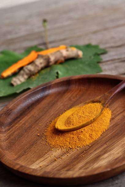 istock Turmeric root powder on wood background 2154549579