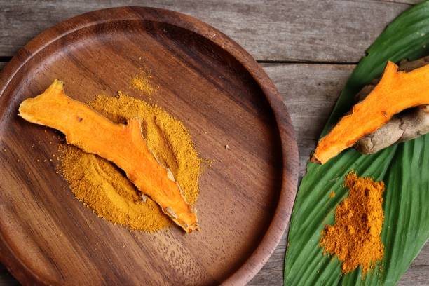 istock Turmeric root powder on wood background 2154549629