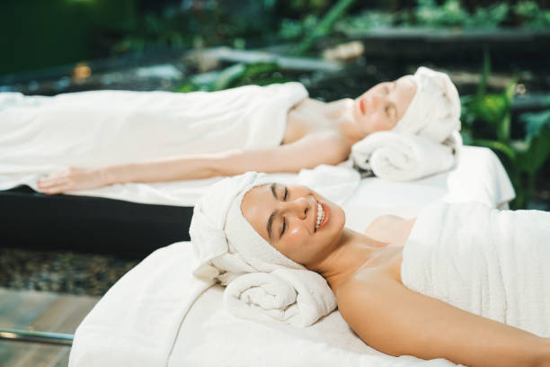 istock Two beautiful young woman lie on bed rounded by peaceful nature. Tranquility. 2154552497
