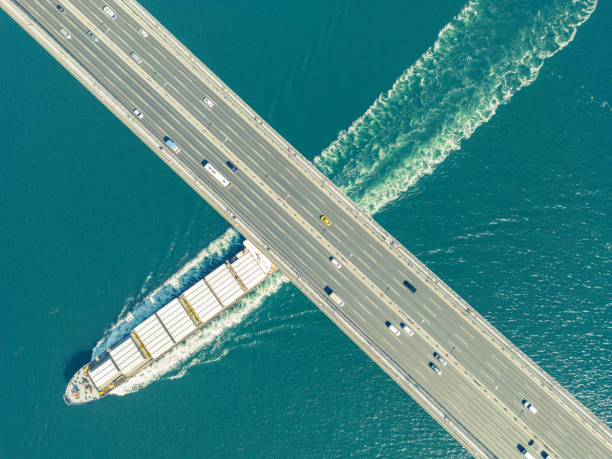 istock Aerial view of a cargo ship passing under bridge. 2154553362