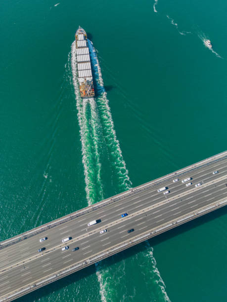 istock Aerial view of a cargo ship passing under bridge. 2154553448