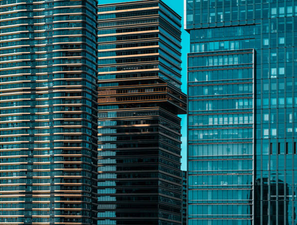 Texture facade features an intricate pattern of windows, reflective surfaces, and modern architectural design, capturing sunlight.