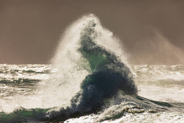 istock Colliding waves creating a dramatic display of power in nature with golden light 2154555409