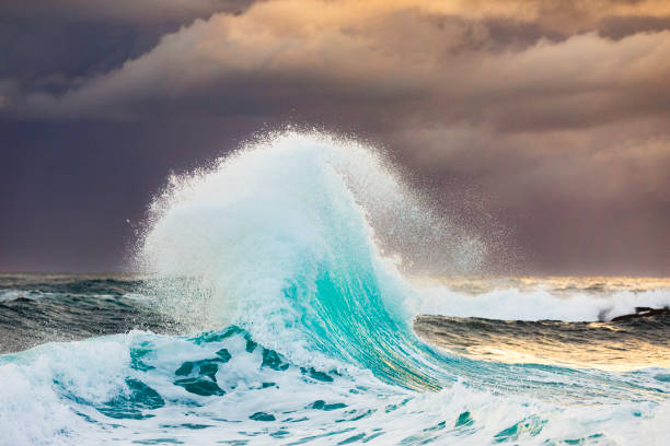 istock Colliding waves creating a unique water formation in nature with golden light 2154555825