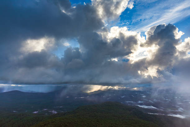 Rain shower over the mountains illuminated by the golden afternoon light. Budawangs region, NSW, Australia.