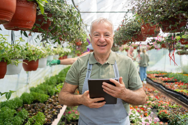 istock Senior male florist using digital tablet while doing quality control at the flower nursery 2154557558