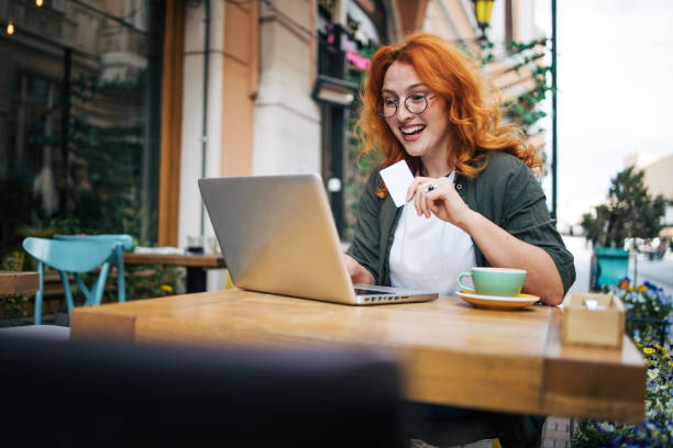 istock Happy young redhead woman relax in cafe  and drinking coffee. She using lap top. 2154558763
